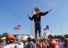 Giant cowboy statue towers over a crowd at an outdoor event