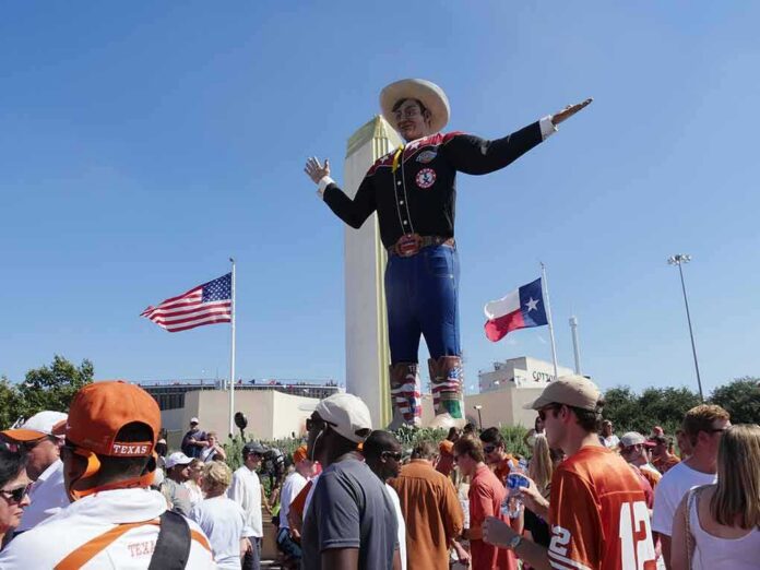 Giant cowboy statue towers over a crowd at an outdoor event
