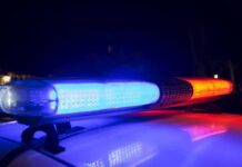 U.S Cop ARRESTED After Russian Spy Allegations Surface Police car light bar flashing blue and red at night