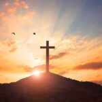 cross on a hill at sunset