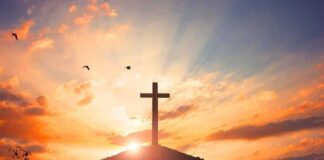 cross on a hill at sunset