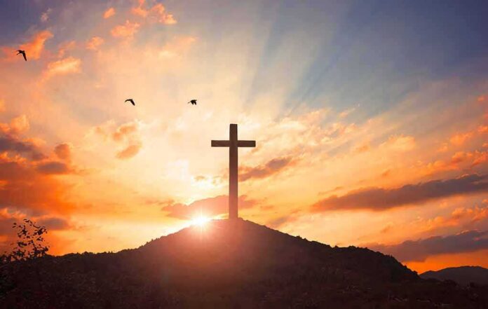 shutterstock_1219010824 cross on a hill at sunset