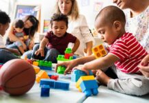Mamdani Launches Babysitting Services To Residents Karyn Polito with toddlers building blocks on a play mat