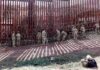 Lithuania Prepares for War – Reinforces Russian Border Soldiers install concertina wire along a tall border fence