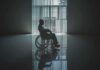 Person in a wheelchair silhouetted by a large window