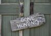 Trump Reverses Disastrous Biden Hunting Ban Weathered wooden sign on green door