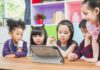 Middle-Schoolers Seeking Out AI Friends Instead of Human Ones children gathered around a tablet at a table