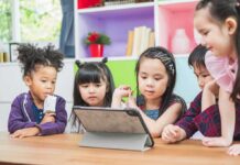 Middle-Schoolers Seeking Out AI Friends Instead of Human Ones children gathered around a tablet at a table