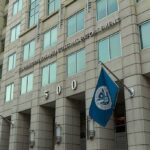 Suspect IDENTIFIED After Federal Building Attack U.S. government building facade with American and blue departmental flags