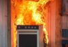 Kitchen stove engulfed in flames against a wall