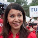 Senator Takes Heartless Jab at Tulsi Amid Her Husband’s Cancer Battle Tulsi Gabbard smiling at an outdoor event surrounded by supporters