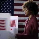 Bipolar Socialist Candidate Demands To End Thanksgiving Voter at a polling booth with an American flag backdrop