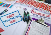 DHS Sting Backfires – Citizens Flagged as “Unlawful” Voter registration table with forms, pens, and informational materials