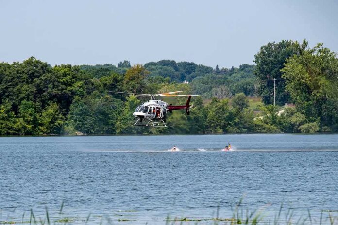 Helicopter hovering low over a lake near kayakers