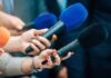 Feds Target Newsom: Criminal Trail Emerges Reporters holding colorful microphones