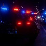 Police vehicles with flashing red and blue lights at night