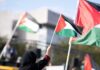 Concert Erupts After Controversial Flag Raise Person waving a Palestinian flag at a rally