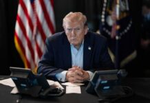 Trump-Xi Showdown: Markets Hold Breath Donald Trump seated at a table between two desk phones