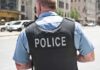Migrants Approved to Apply For Police Jobs Police officer in uniform from behind on a city street