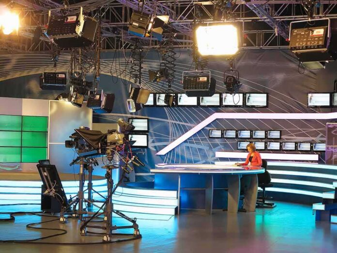 News studio with anchor at desk and cameras