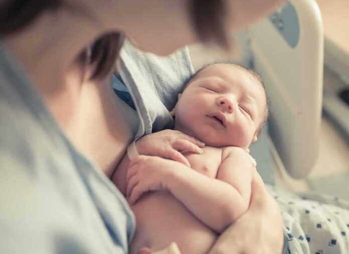 newborn baby sleeping in a parent's arms