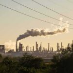 UAE’s Secret STRIKE on Iran EXPOSED Industrial refinery with smokestack emitting plume at sunset