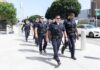 Mayor Busted on Grand Theft and Fraud Charges Police officers walking in formation on a city sidewalk
