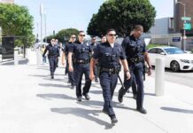 Mayor Busted on Grand Theft and Fraud Charges Police officers walking in formation on a city sidewalk