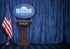 TV Networks Band Together in Trump BLACKOUT White House press briefing podium with U.S. flag and blue curtain