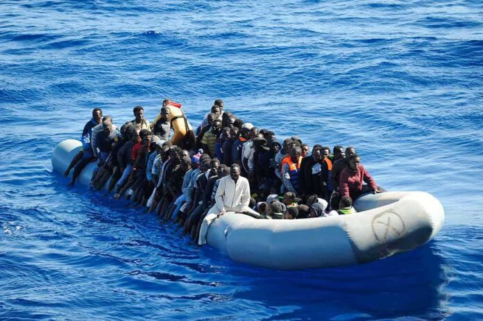 shutterstock_1351234694 Dontrelle Inman and Colin David Jones among a crowded inflatable boat at sea