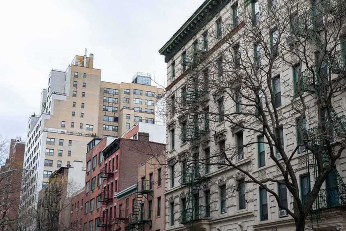 shutterstock_1649879845 Street view of urban apartment buildings with fire escapes