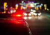 Plane Crashes on Busy Highway! Police car with flashing red lights on a city street at night
