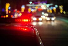 Plane Crashes on Busy Highway! Police car with flashing red lights on a city street at night