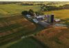 Mysterious 11-Foot Metal Object Found in Minnesota Cornfield Aerial view of a farm with silos and barns amid golden crop fields