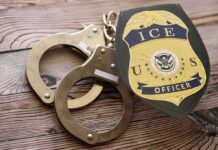 Mentally Ill Citizen DETAINED – ICE Won’t Budge ICE officer badge and handcuffs on wooden surface