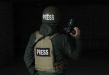 Cartel Trainees Being Sent to Ukraine Schools Press photographer in helmet and vest holding a camera