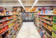 Half of Americans Skipping Meals Amid Rising Grocery Prices Grocery store aisle with stocked shelves and refrigerated section ahead